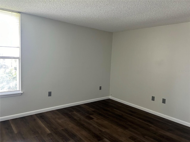 unfurnished room featuring dark hardwood / wood-style floors and a textured ceiling