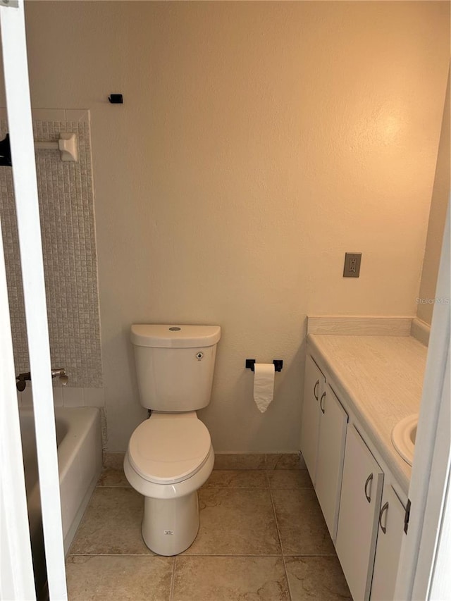 bathroom with a washtub, tile patterned floors, vanity, and toilet