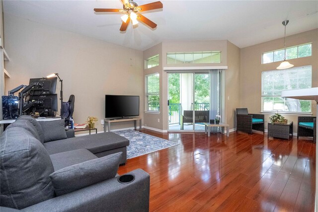 living room featuring a towering ceiling, hardwood / wood-style floors, and ceiling fan