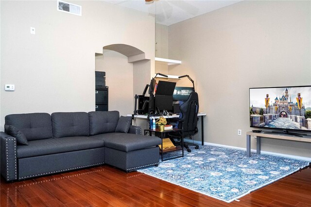 living room with ceiling fan and dark wood-type flooring