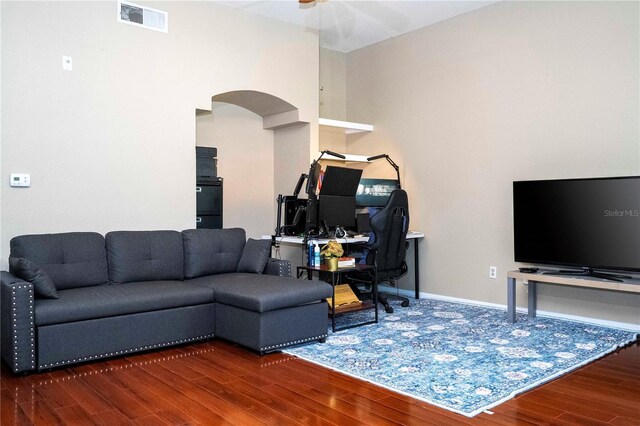 living room with dark hardwood / wood-style flooring and ceiling fan