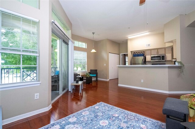 living room featuring ceiling fan and dark wood-type flooring