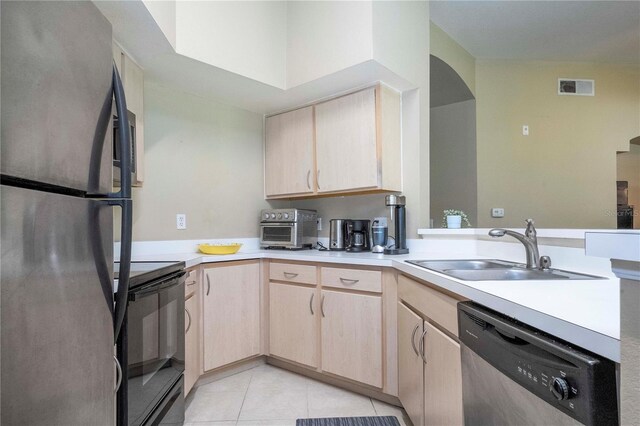 kitchen featuring light brown cabinets, kitchen peninsula, appliances with stainless steel finishes, sink, and light tile floors