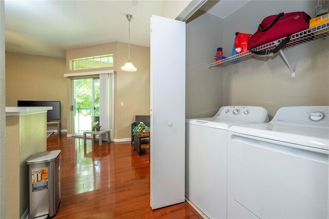 clothes washing area with washer and clothes dryer and hardwood / wood-style floors