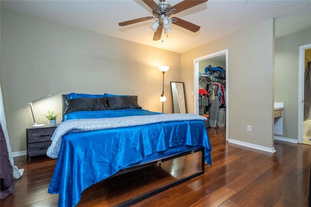 bedroom with a closet, ceiling fan, dark hardwood / wood-style flooring, and a spacious closet