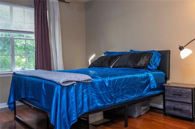 bedroom with dark hardwood / wood-style floors