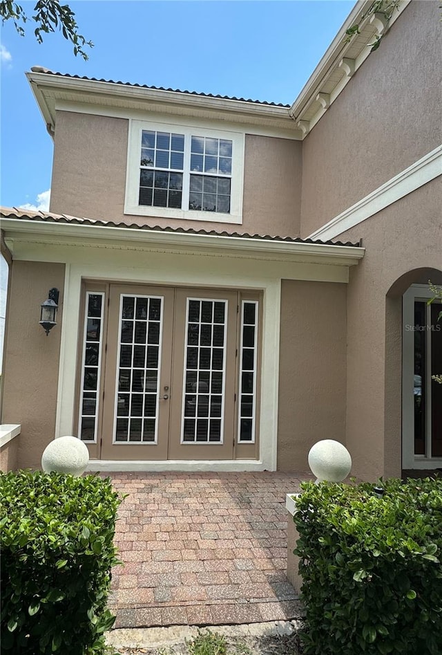 view of exterior entry featuring french doors and a patio area