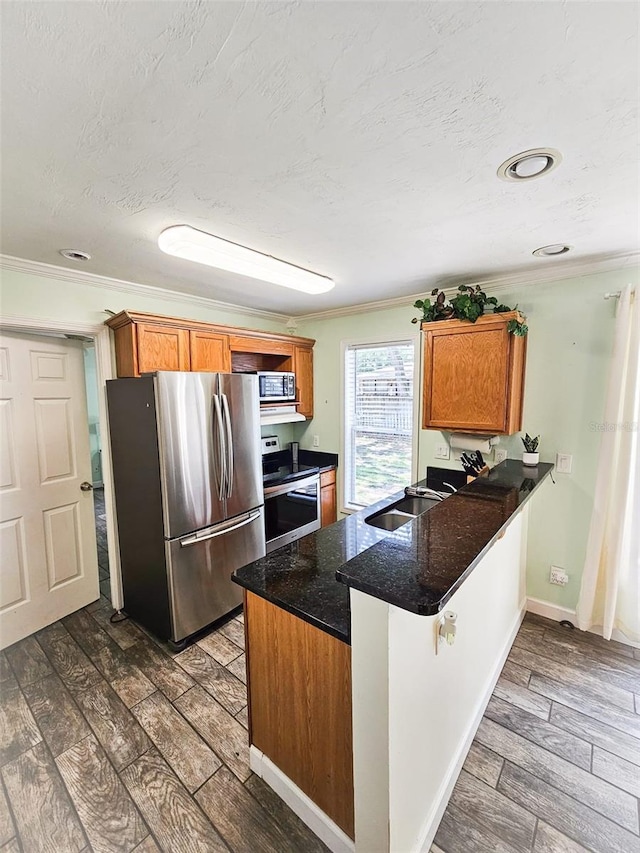 kitchen featuring kitchen peninsula, crown molding, dark hardwood / wood-style flooring, and appliances with stainless steel finishes