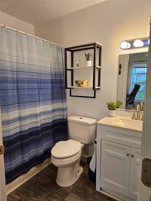 bathroom featuring vanity, toilet, and curtained shower