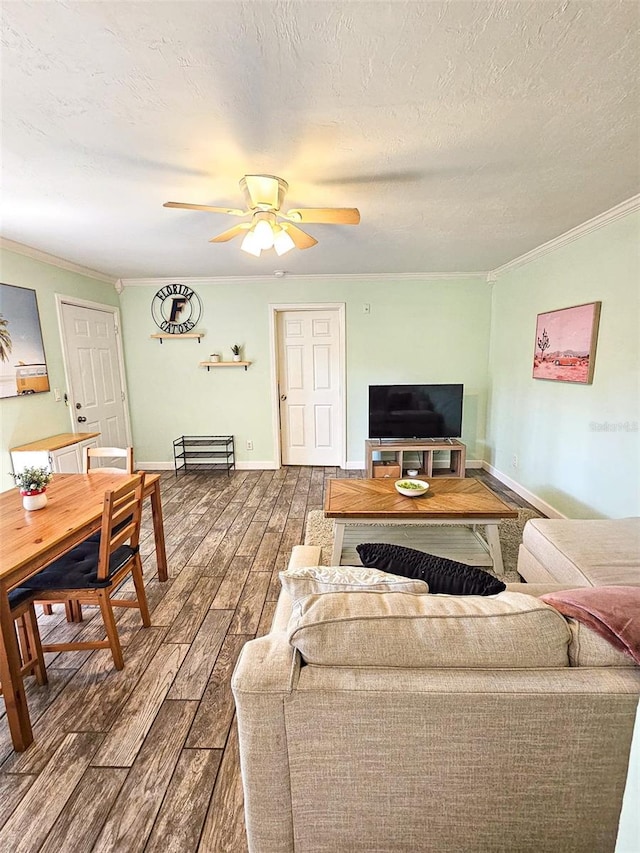 living room featuring hardwood / wood-style floors, a textured ceiling, ceiling fan, and crown molding