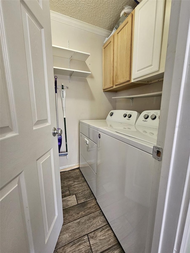 washroom featuring cabinets, a textured ceiling, crown molding, and washing machine and clothes dryer