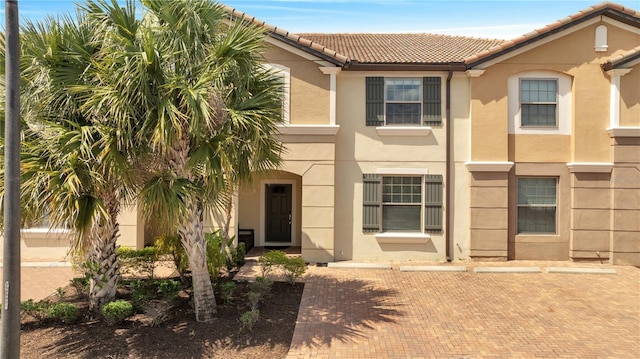 view of front of property featuring a tiled roof and stucco siding