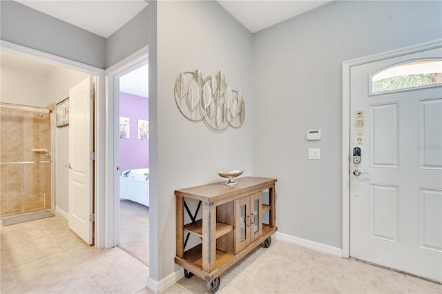 foyer featuring baseboards and light tile patterned floors