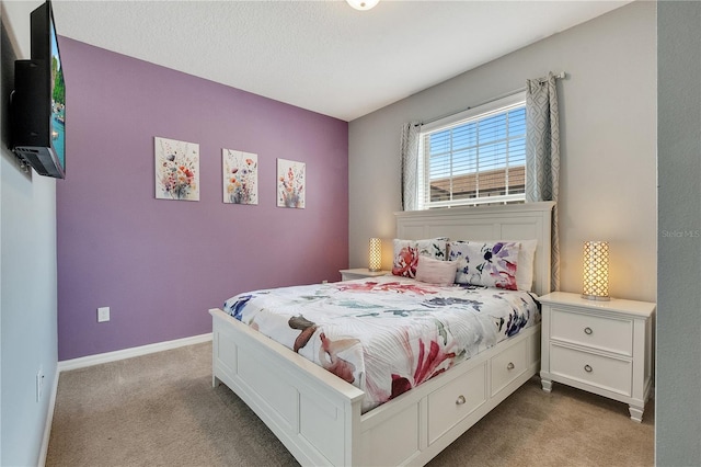 carpeted bedroom featuring a textured ceiling and baseboards