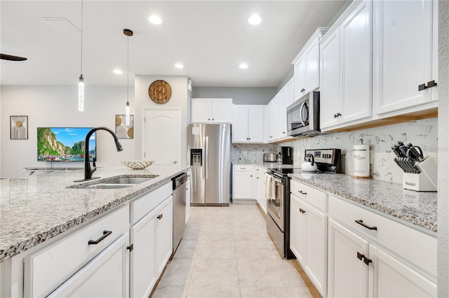 kitchen featuring decorative light fixtures, tasteful backsplash, appliances with stainless steel finishes, sink, and light tile floors