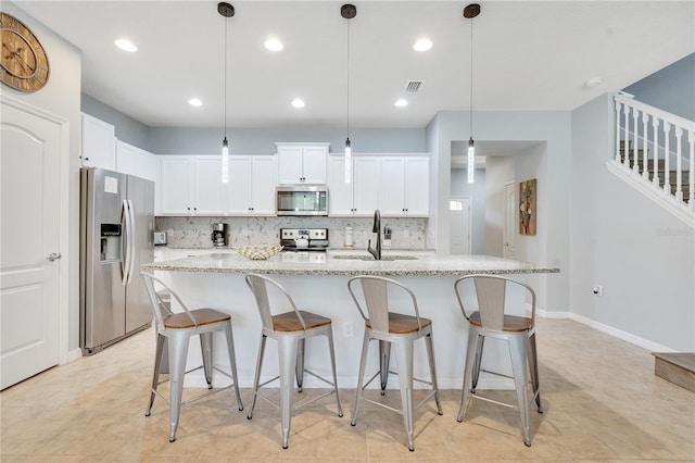 kitchen with stainless steel appliances, sink, tasteful backsplash, and pendant lighting