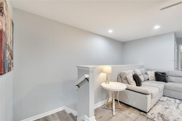 living room featuring light wood-style floors, baseboards, and recessed lighting