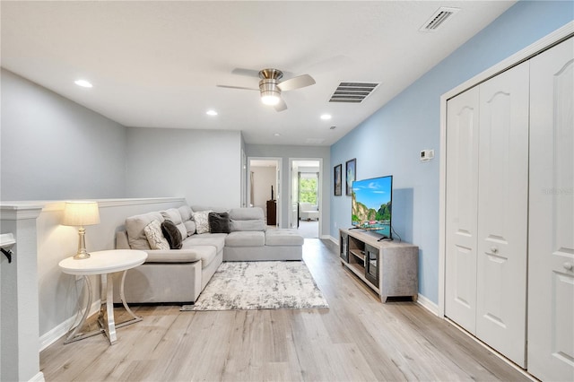 living room with light hardwood / wood-style floors and ceiling fan