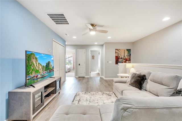 living room featuring ceiling fan and light hardwood / wood-style flooring