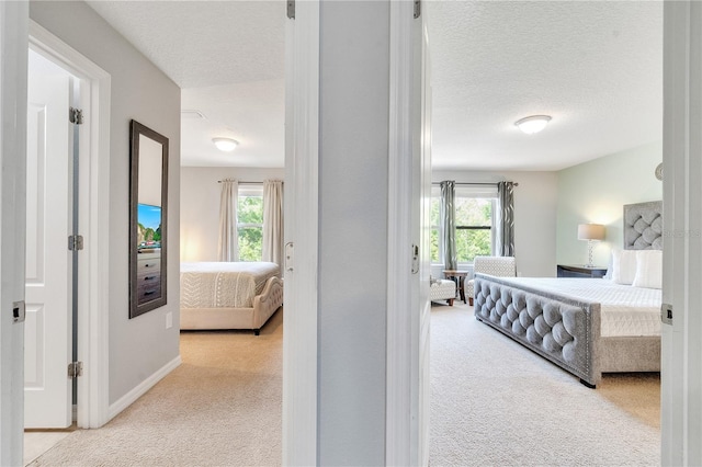 carpeted bedroom with baseboards and a textured ceiling