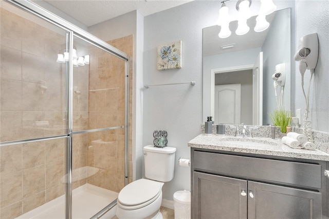 bathroom featuring vanity, a shower stall, and toilet