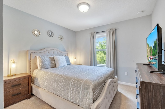 carpeted bedroom with a textured ceiling and baseboards