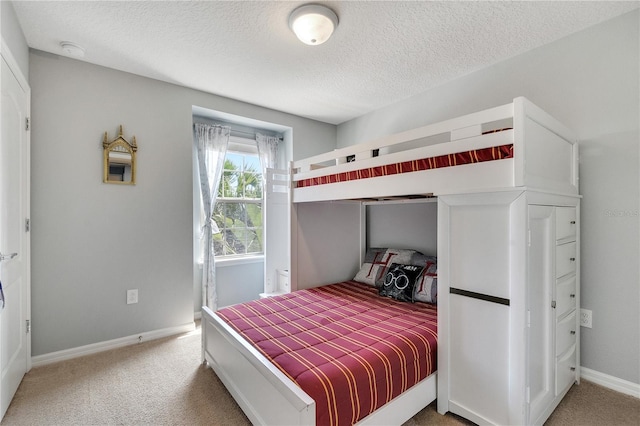 carpeted bedroom featuring baseboards and a textured ceiling