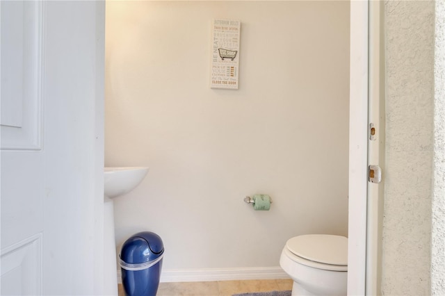 bathroom featuring tile flooring and toilet