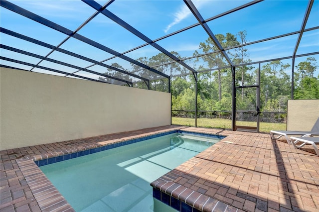 view of swimming pool with glass enclosure and a patio