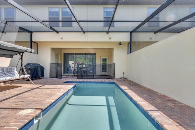 view of pool with grilling area and a patio area