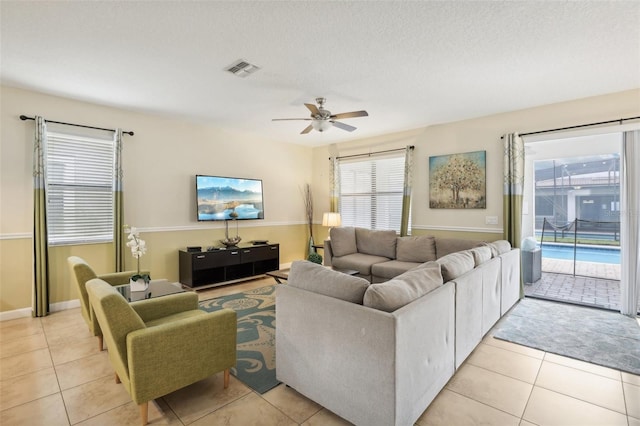 tiled living room featuring a textured ceiling and ceiling fan