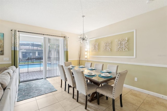 dining area with a textured ceiling, a chandelier, and light tile patterned flooring