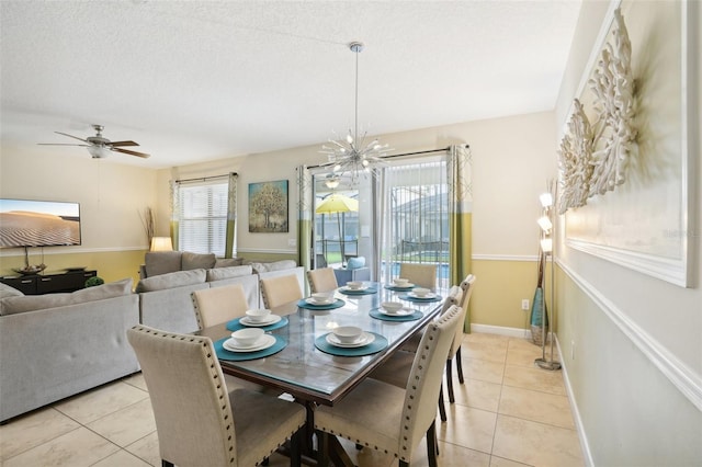 tiled dining room featuring ceiling fan with notable chandelier, plenty of natural light, and a textured ceiling