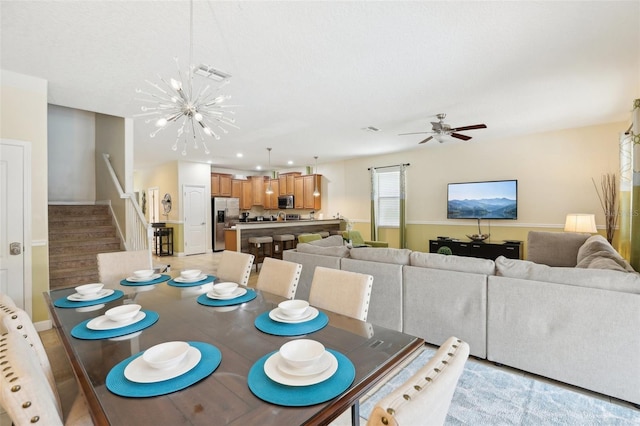 dining space with ceiling fan with notable chandelier