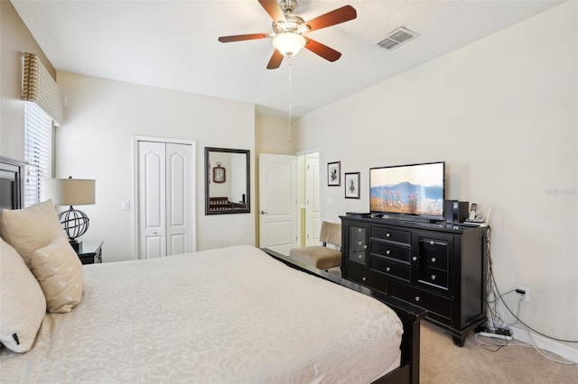 bedroom with ceiling fan, light colored carpet, and a closet