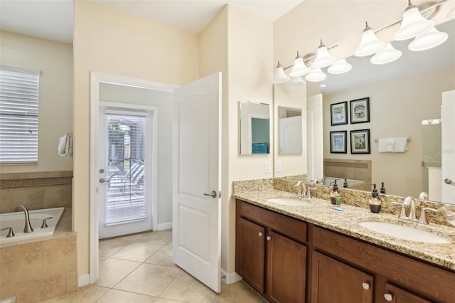 bathroom with tile patterned flooring, tiled tub, and vanity