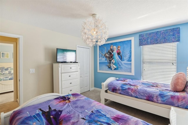 carpeted bedroom featuring a closet and an inviting chandelier