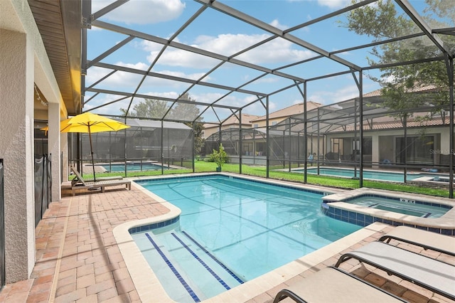 view of swimming pool featuring a lanai, a patio area, and an in ground hot tub