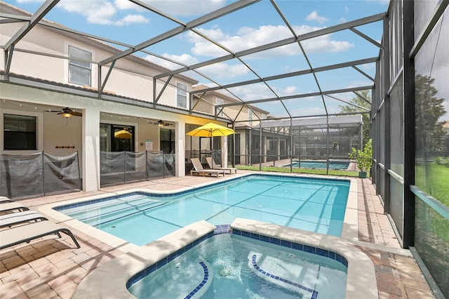 view of pool with an in ground hot tub, a lanai, ceiling fan, and a patio area