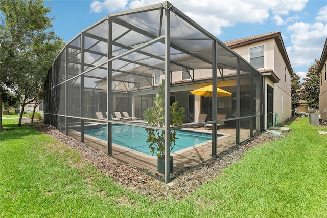 rear view of property featuring a lanai, a patio area, a yard, and central AC unit