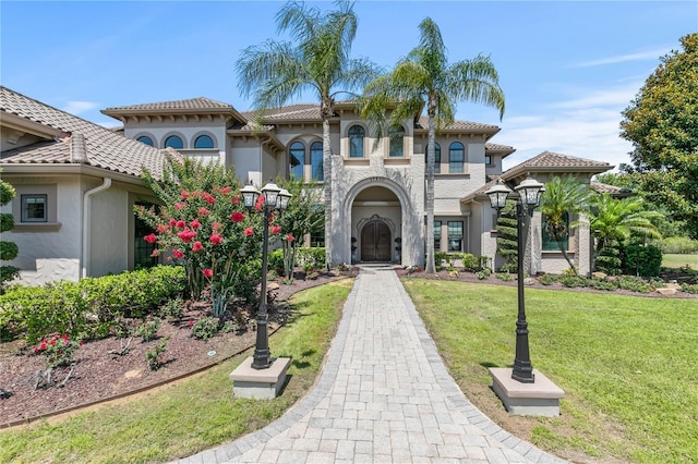 mediterranean / spanish home with a front lawn