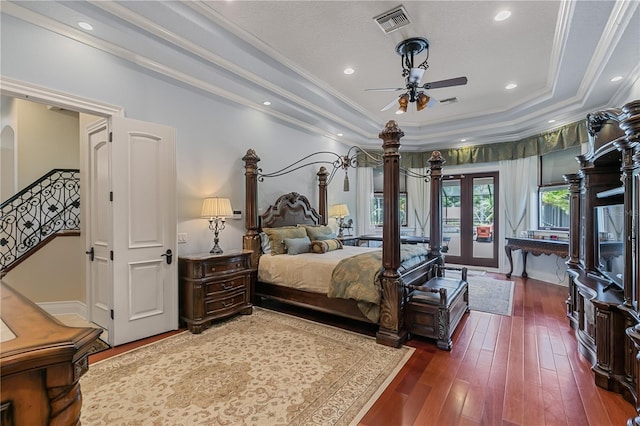 bedroom featuring ceiling fan, french doors, dark hardwood / wood-style flooring, a tray ceiling, and ornamental molding