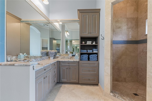 bathroom featuring vanity, a tile shower, and ornamental molding