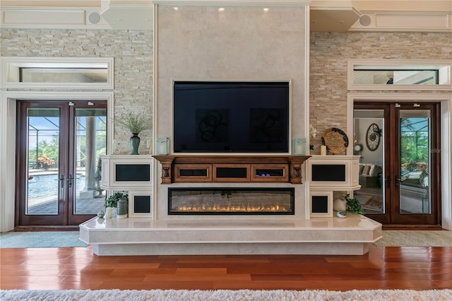 living room with french doors, a healthy amount of sunlight, and hardwood / wood-style flooring