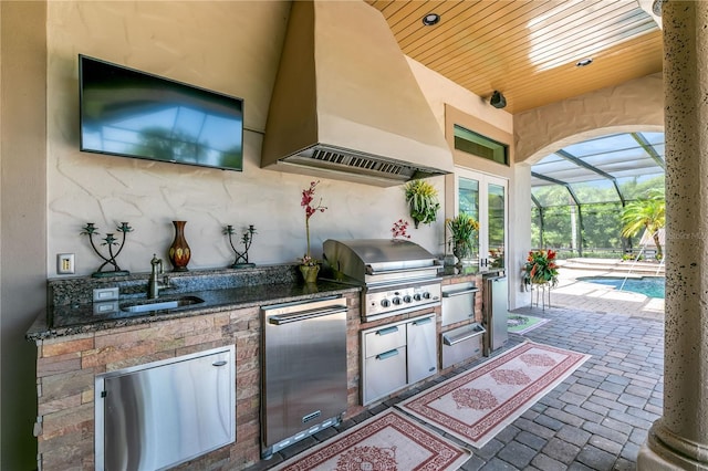 view of patio with a grill, a lanai, exterior kitchen, and sink