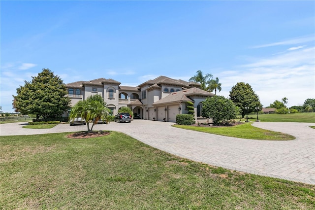 mediterranean / spanish home featuring a front yard and a garage