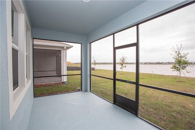 unfurnished sunroom featuring a water view