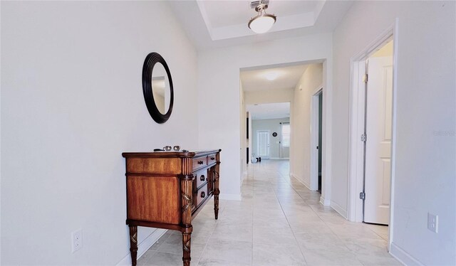 hallway featuring a tray ceiling