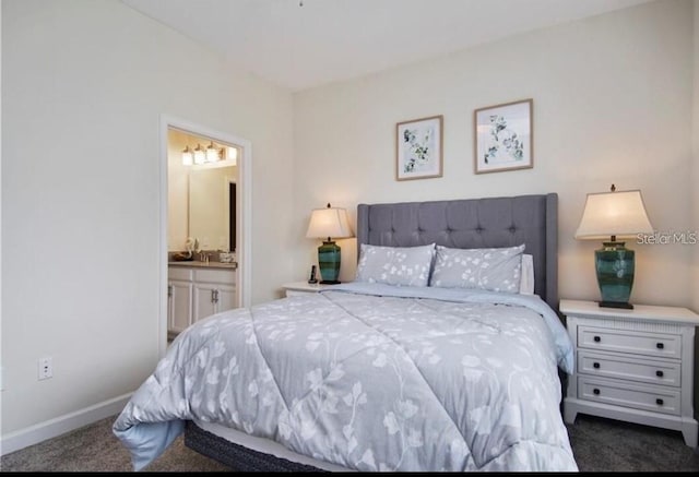 bedroom with ensuite bathroom and dark carpet