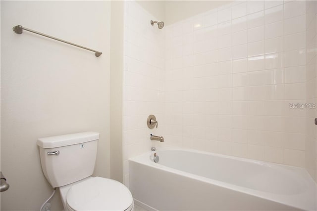 bathroom with tiled shower / bath combo and toilet